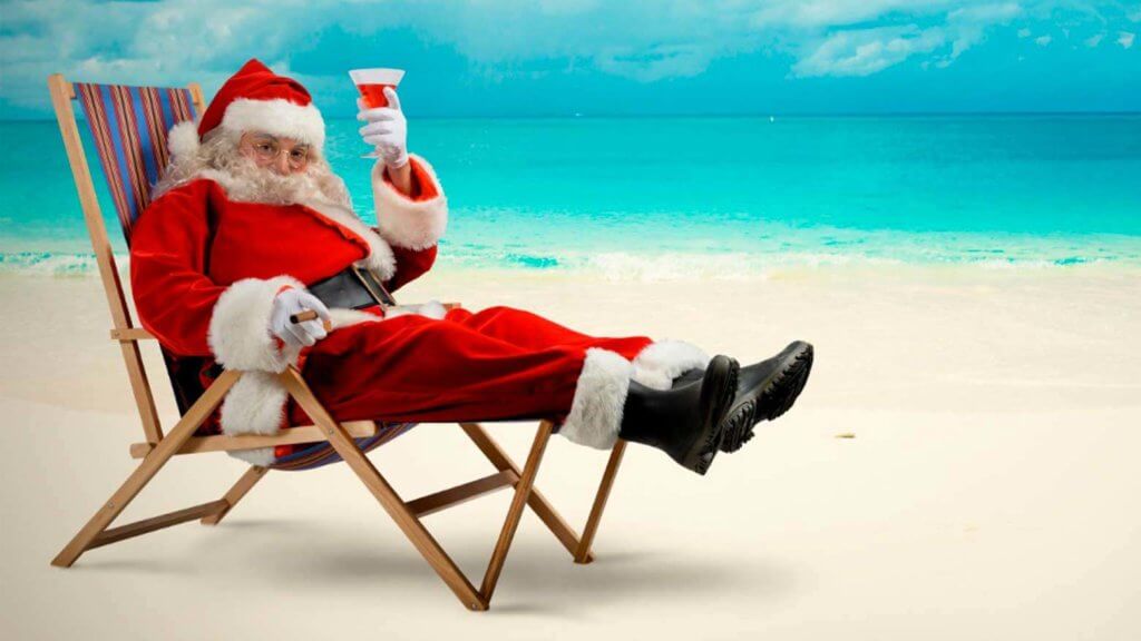 Father Christmas on a beach sitting in a deckchair